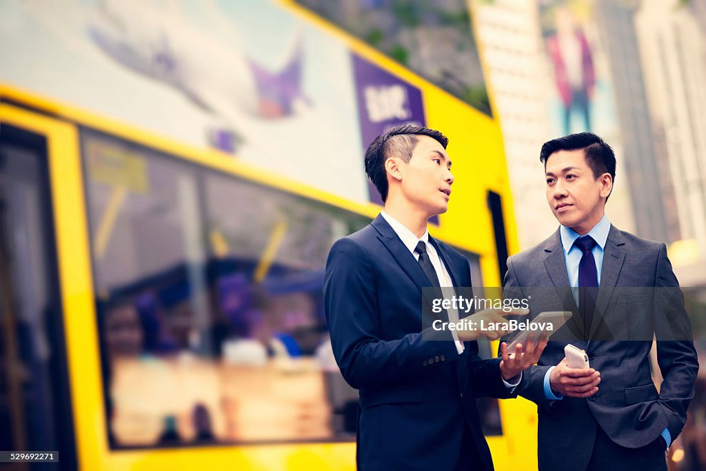 Two Asian young men talking on the street