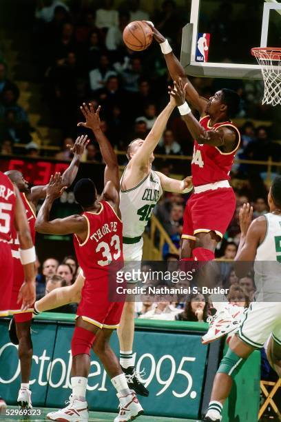 Hakeem Olajuwon of the Houston Rockets goes for a block against the Boston Celtics during the NBA game at Boston Garden circa 1995 in Boston,...