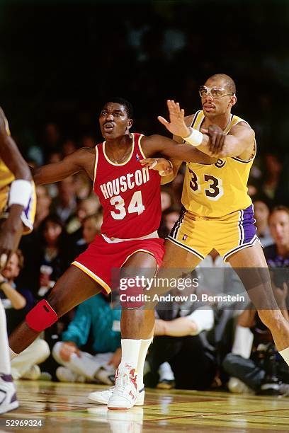 Hakeem Olajuwon of the Houston Rockets battles for position against Kareem Abdul-Jabbar of the Los Angeles Lakers during an NBA game at the Forum...