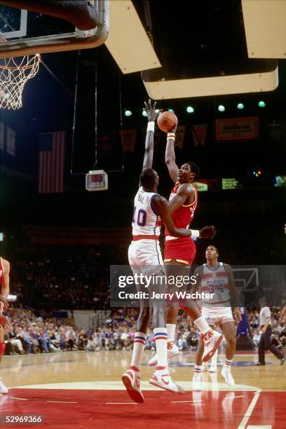 Hakeem Olajuwon of the Houston Rockets takes a hookshot over Manute Bol of the Washington Bullets during an NBA game circa 1986 in Washington, D.C....