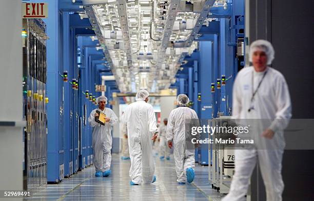 Workers walk in an IBM 12-inch wafer chip fabricating plant July 20, 2004 in Fishkill, New York.