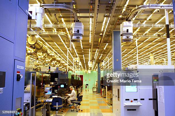Workers work on computers in an IBM 12-inch wafer chip fabricating plant July 20, 2004 in Fishkill, New York.