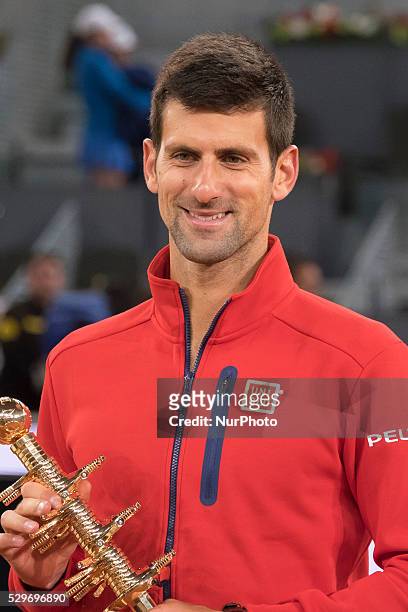 Novak Djokovic of Serbia holds aloft his winners trophy after his three set victory against Andy Murray of Great Britain in the mens final during day...