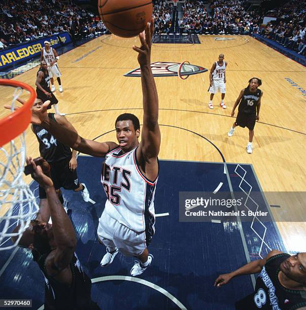 Jason Collins of the New Jersey Nets shoots a layup over Kevin Garnett of the Minnesota Timberwolves during a game at Continental Airlines Arena on...