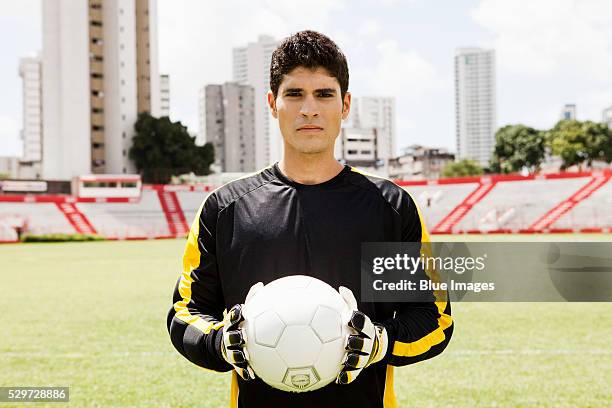 soccer player standing on field - keepershandschoen stockfoto's en -beelden