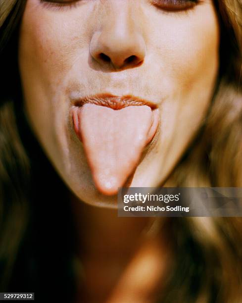 a woman sticking her tongue out - menschliche zunge stock-fotos und bilder