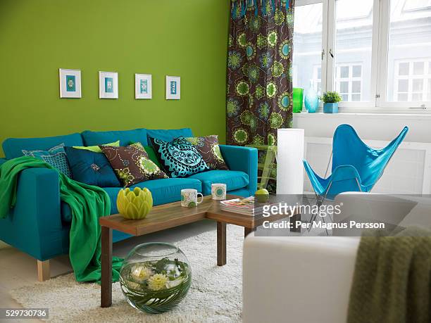 a blue sofa in a living room - green curtain stock pictures, royalty-free photos & images