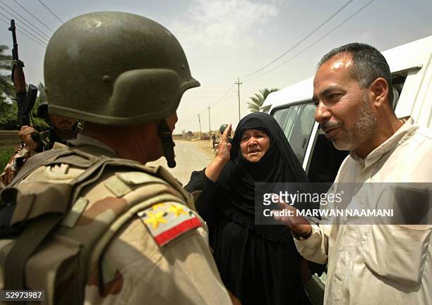 An Iraqi man and his wife speak with the Brigadier General Aziz Swady, commander of Iraqi al-Muthana Brigade, as he goes on foot patrol with his...