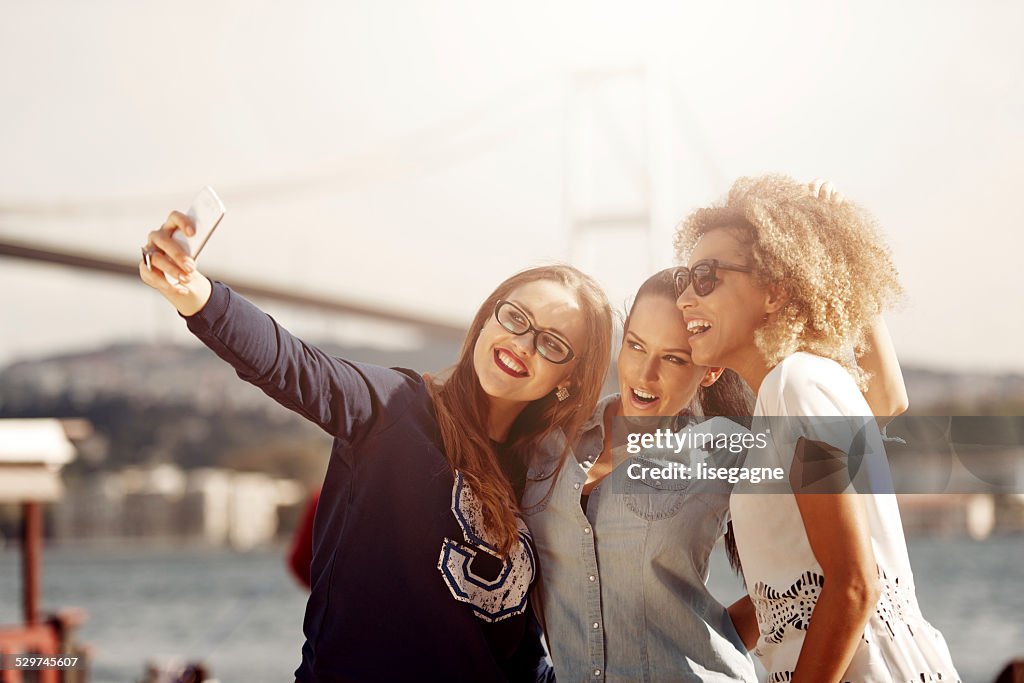 Friends taking pictures of friends in front of Bosphorus bridge