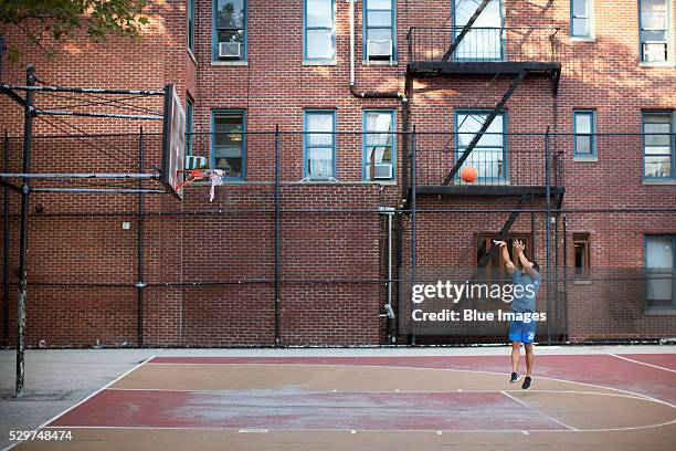 man playing basketball outdoors - vintage basketball court stock pictures, royalty-free photos & images