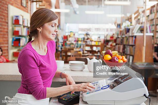 woman using cash register - register fotografías e imágenes de stock