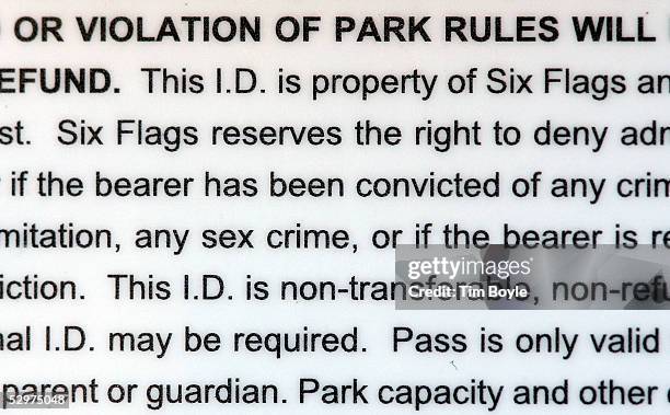 Fine print on the back of a Six Flags season ticket is visible outside its Great America theme park May 24, 2005 in Gurnee, Illinois. Looking to...