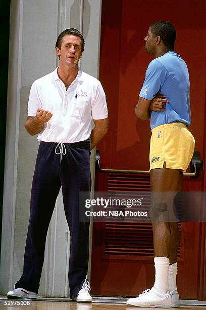 Head Coach Pat Riley of the Los Angeles Lakers talks with 'Magic' Johnson during a Lakers practice session circa 1988 in Los Angeles, California....