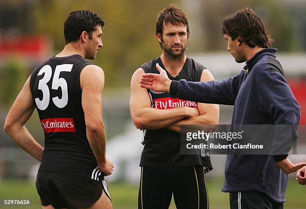 Simon Prestigiacomo and Shane Wakelin talk with specialist coach Stephen Silvagni during the Collingwood Magpies training session at Lexus Oval on...