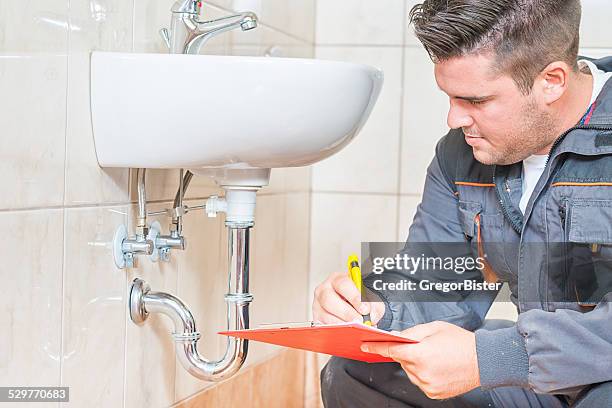 young plumber with clip board - rörmokare bildbanksfoton och bilder