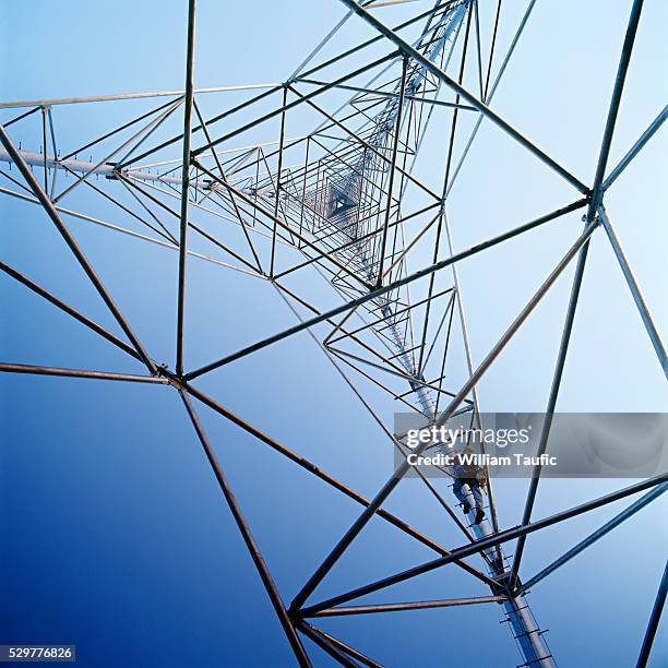 communications tower worker scaling tower - antennes photos et images de collection