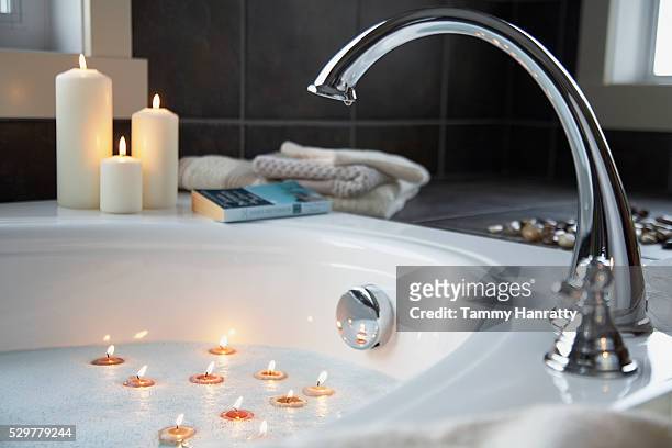 tealights floating in bathtub - schaumbad stock-fotos und bilder