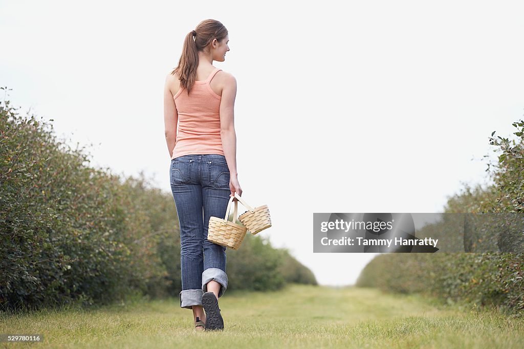 Woman walking through orchard