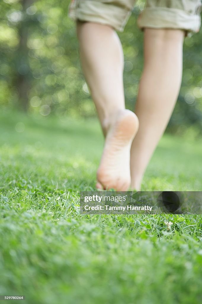 Woman walking bare foot in grass