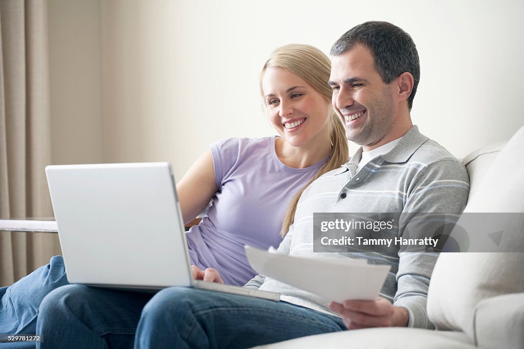 Couple happily paying bills online
