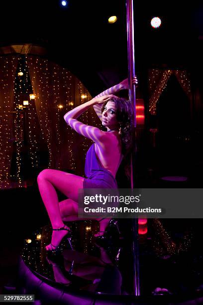 woman portrait leaning against a pole in club - pole dancing heels stock-fotos und bilder