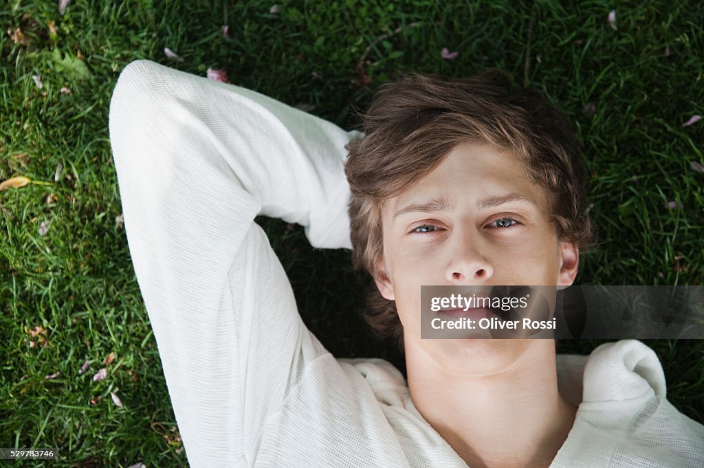 Young man lying in grass