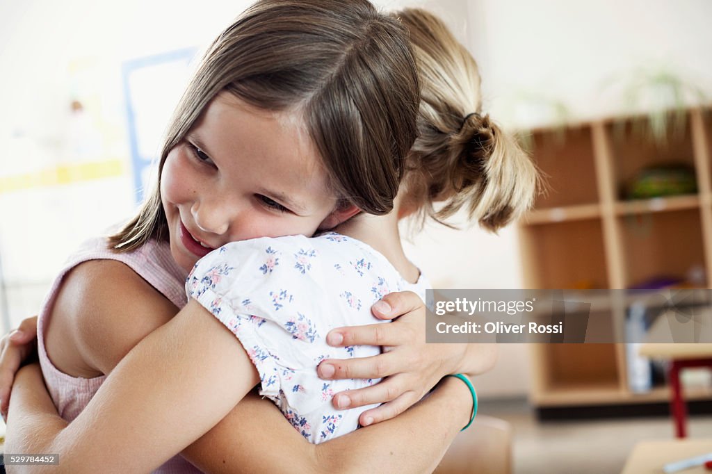 Girls hugging in classroom