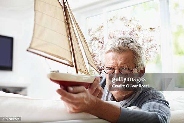 man holding model sailboat - scatola di montaggio foto e immagini stock