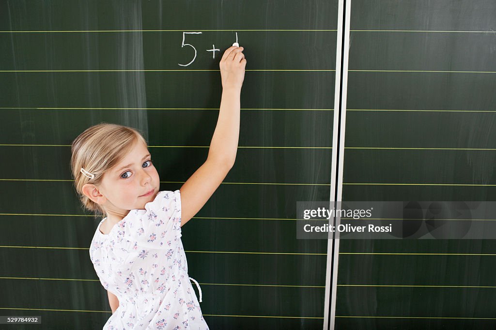 Girl writing on blackboard