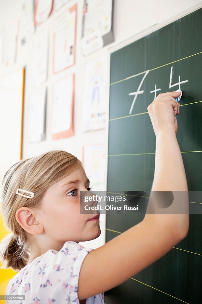 Girl writing on blackboard