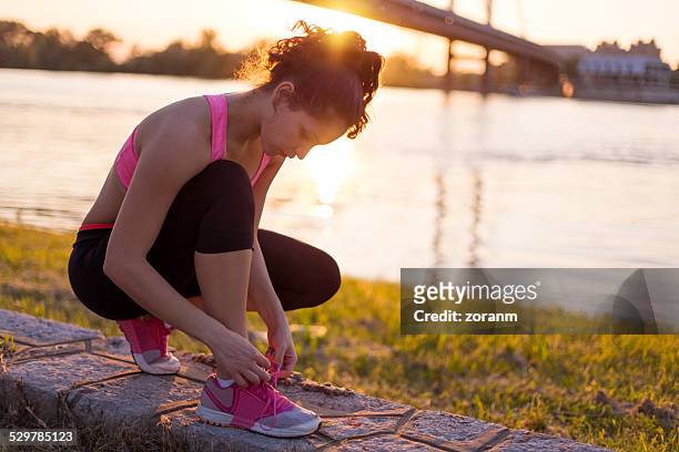 tying sports shoes - untied shoelace stock pictures, royalty-free photos & images