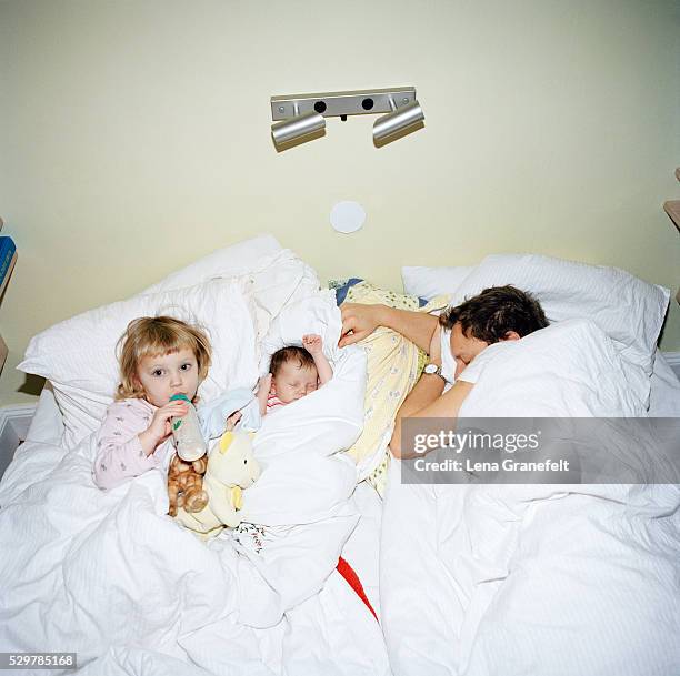 a family lying in bed, sweden - letto matrimoniale foto e immagini stock