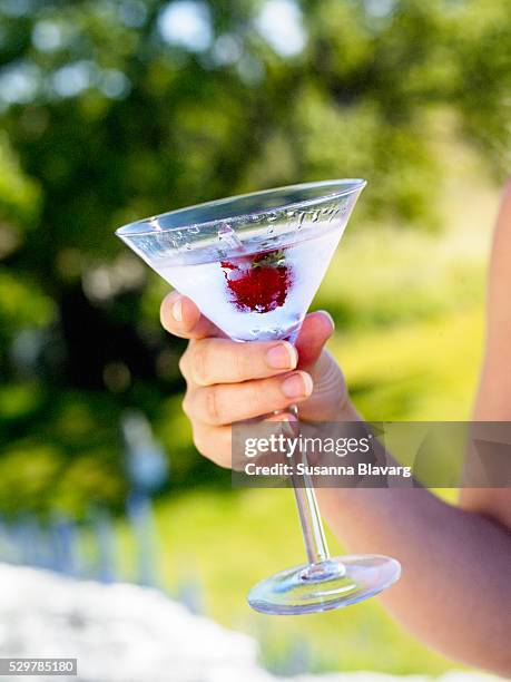 martini with a strawberry, sweden. - summer cocktails garden party drinks stockfoto's en -beelden