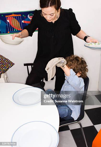 a mother setting the dinner table by her son, sweden. - sons of anarchy stock-fotos und bilder