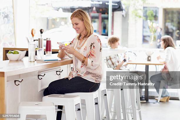 young woman texting at bar counter - tammy bar stock pictures, royalty-free photos & images