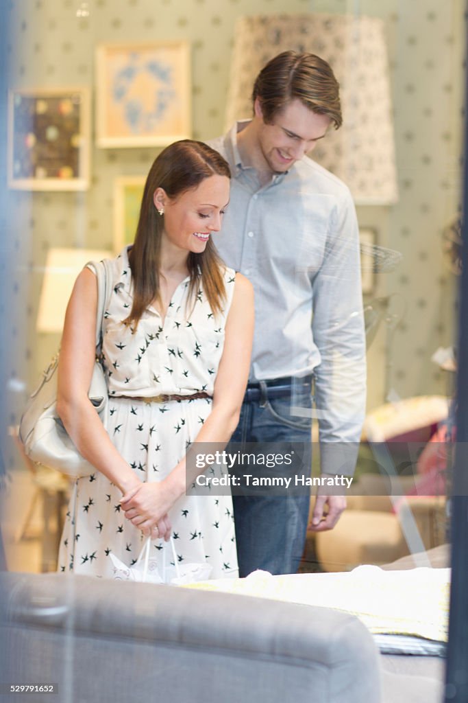 Customers looking at bed in furniture store