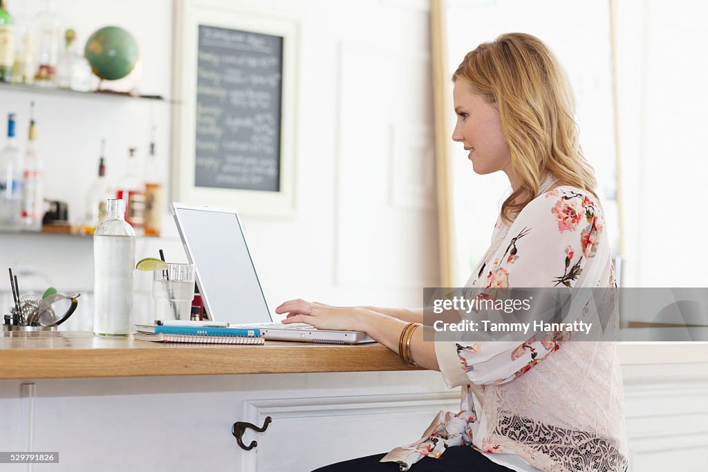 Woman using laptop in cafe