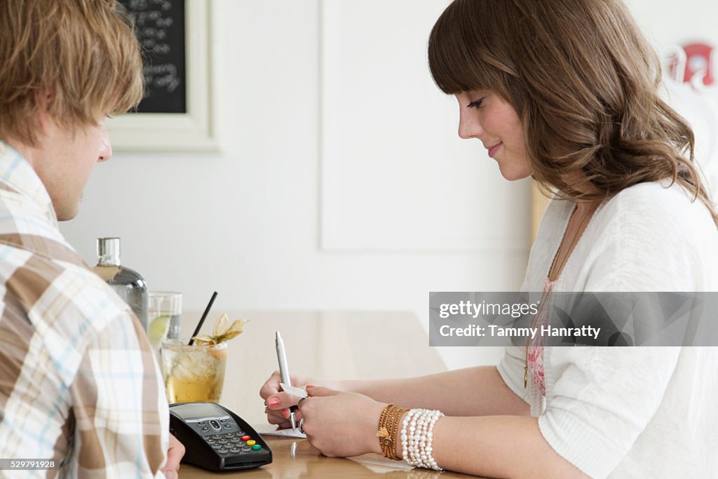 Female paying bill at cafe