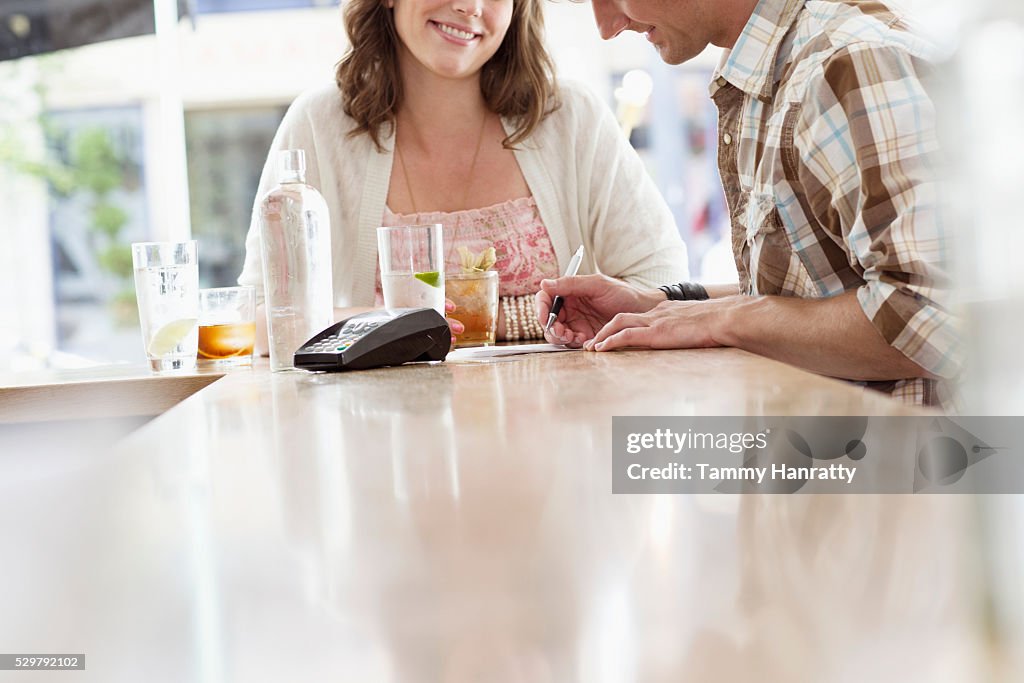 Mid adult man paying bill in bar