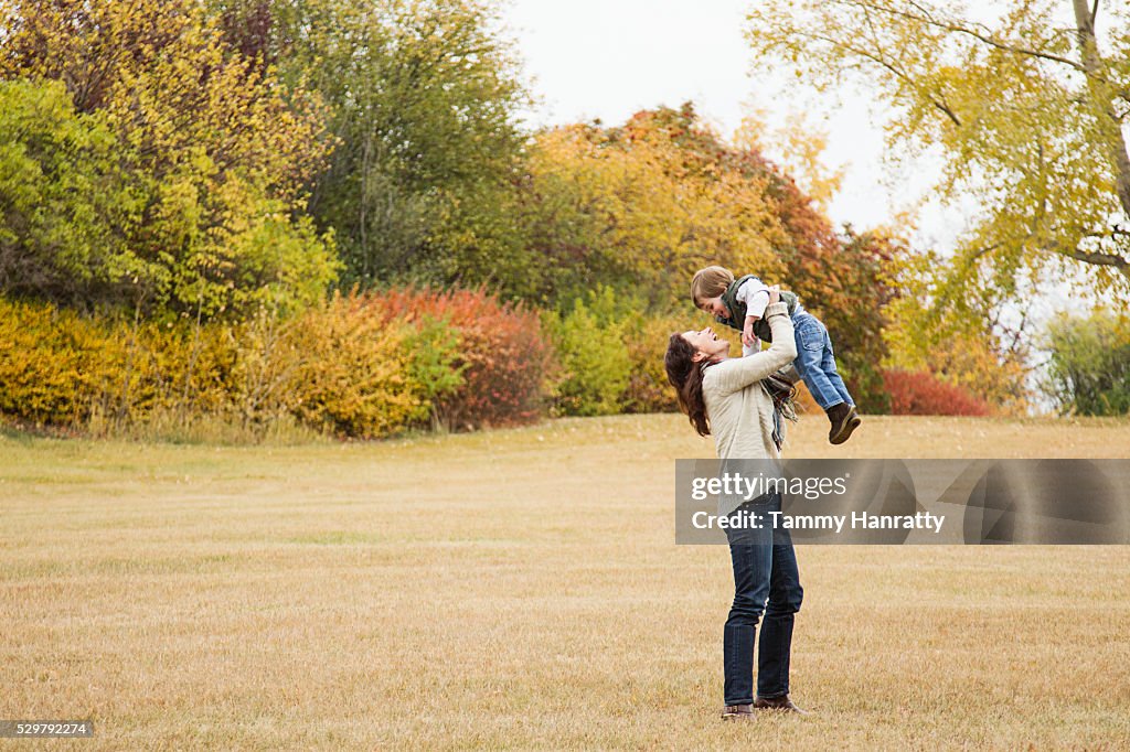 Mother lifting his son (4-5) up in air