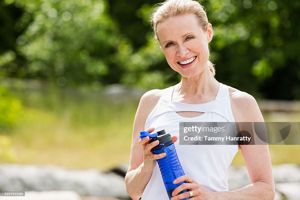 Portrait of senior woman holding bidon outdoors