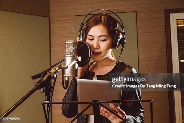 young lady recording vocals in studio - opnamestudio stockfoto's en -beelden