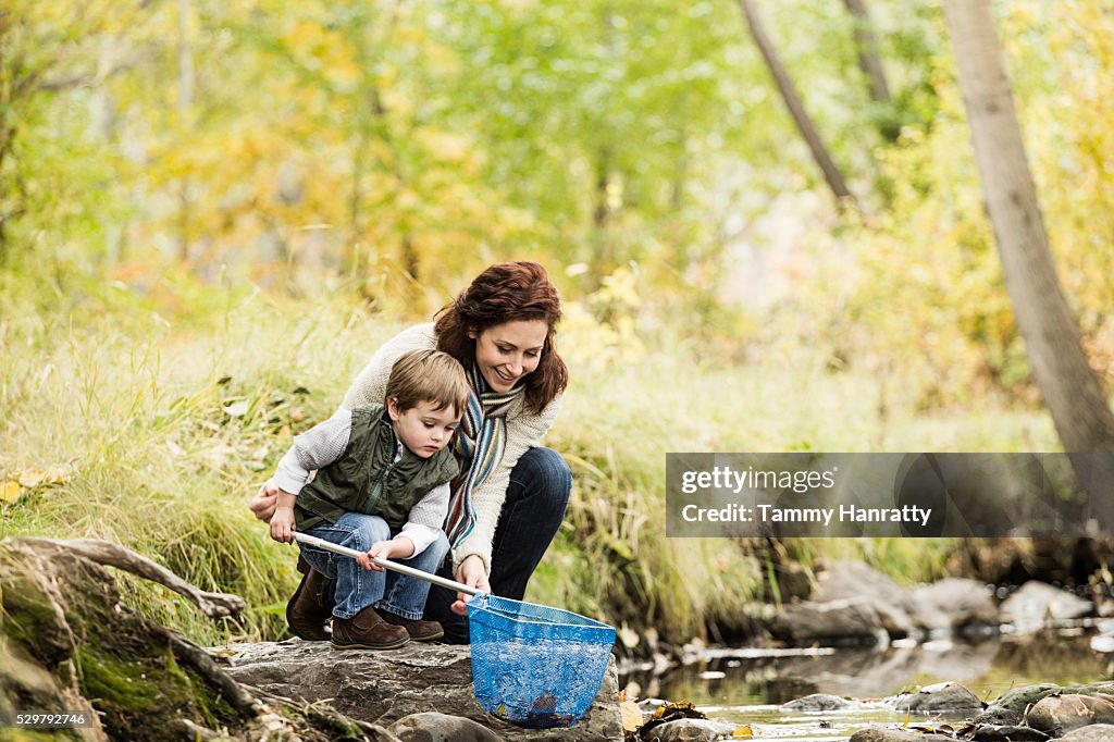 Mother and son (4-5) fishing in mountain stream