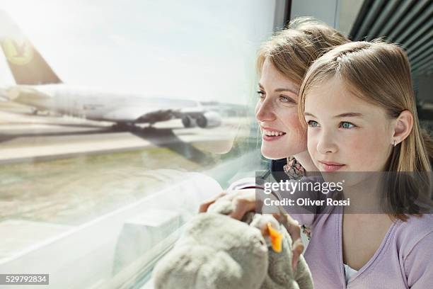 mother and daughter (5-6) watching airplanes at airport - family at airport fotografías e imágenes de stock