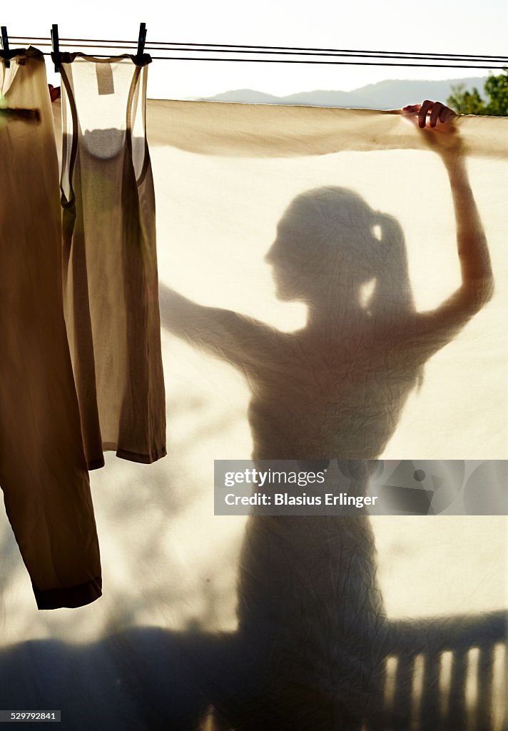 Young woman hangs laundry