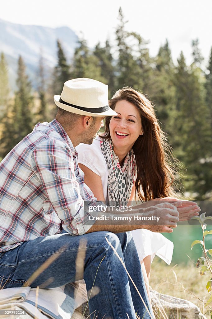 Mid-adult couple relaxing at lakeshore