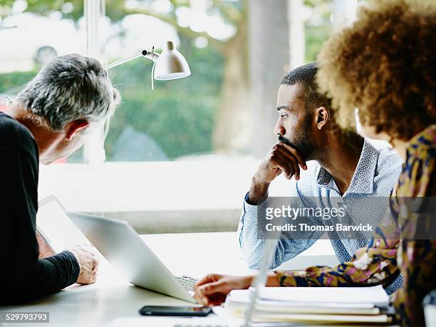 mature businessman presenting project to coworkers - colleagues supporting stockfoto's en -beelden