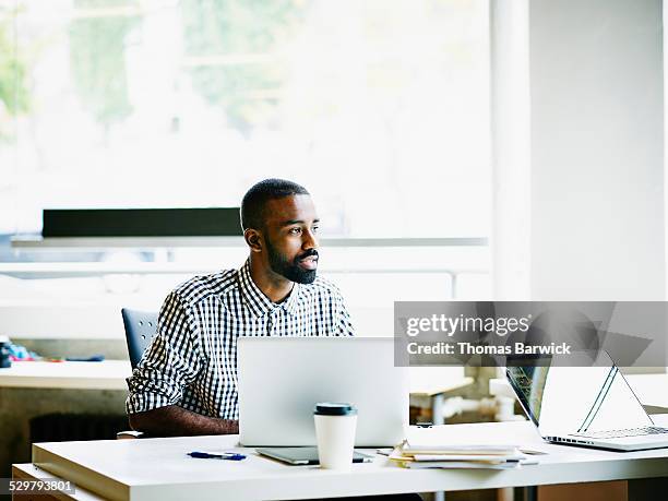 businessman working on laptop at workstation - selective focus stockfoto's en -beelden