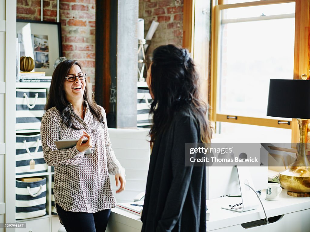 Laughing businesswomen in discussion in office