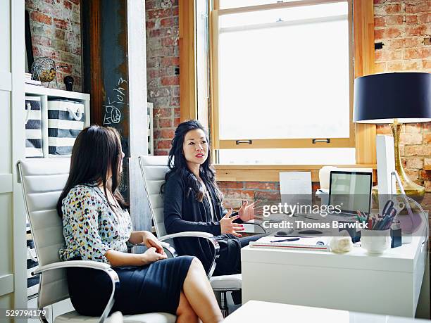 female business owners having an informal meeting - leanincollection foto e immagini stock